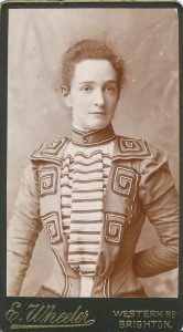 A photo of Grace as a young adult. She looks very smart here. Her jacket has spirals and stripes on. She has her hair pinned back.