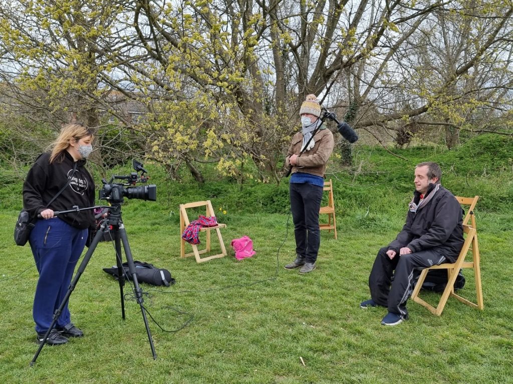 Justin and 2 volunteers learn film-making skills in the park.